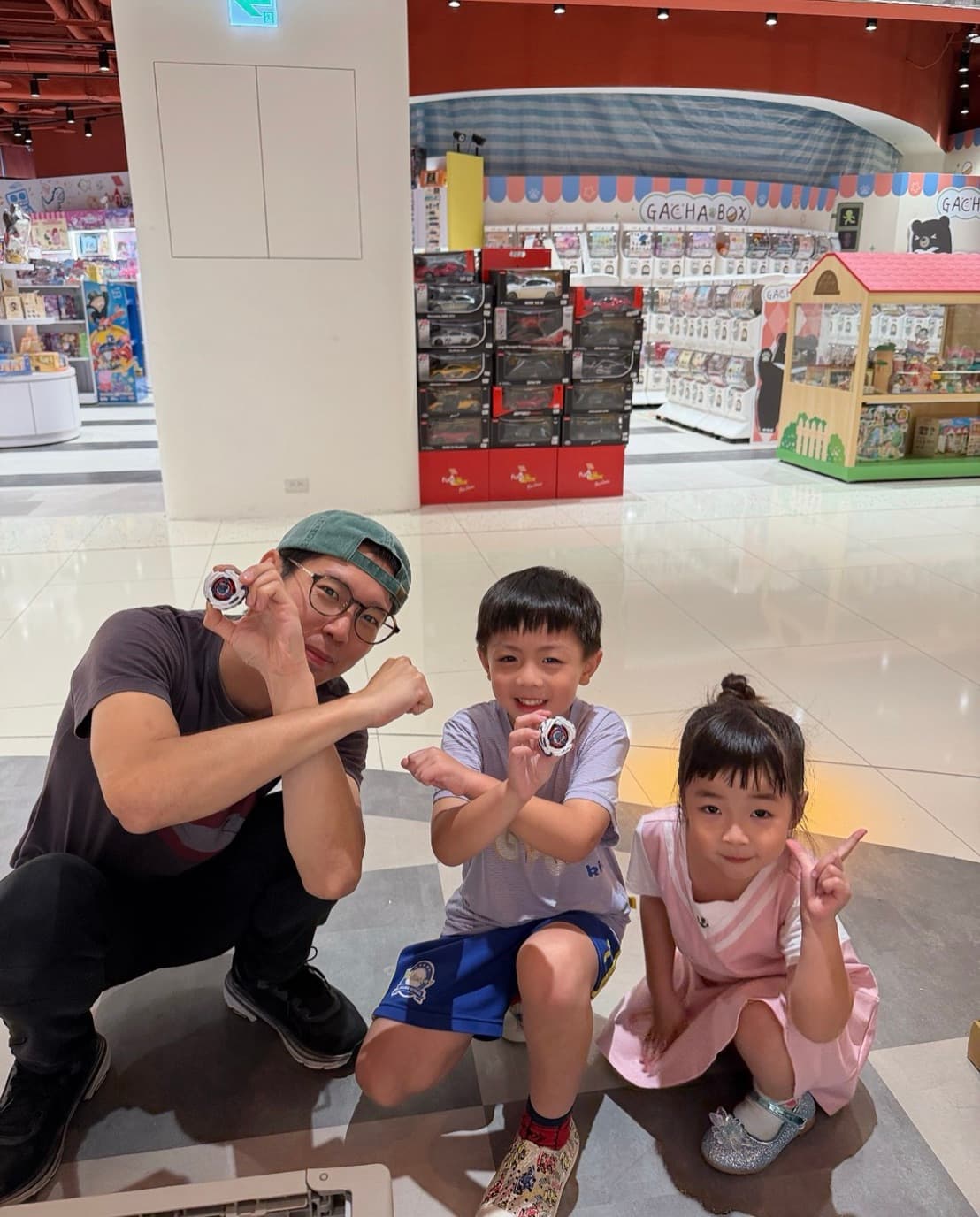 龍宮醫生蹲下與兩位小朋友一起比出戰鬥陀螺手勢